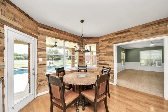 1140 Bartlett Rd, Katy, TX 77493 - dining area featuring wooden walls, healthy amount of natural light, light wood-type flooring, and a chandelier