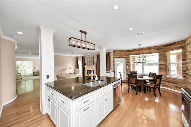 1140 Bartlett Rd, Katy, TX 77493 - kitchen with a sink, decorative columns, dishwasher, baseboards, and light wood-type flooring