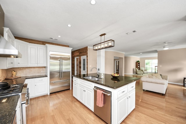 1140 Bartlett Rd, Katy, TX 77493 - kitchen featuring stainless steel appliances, a sink, light wood-type flooring, an island with sink, and recessed lighting