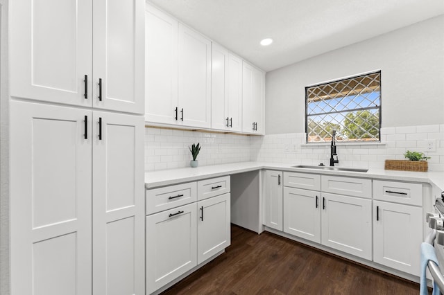 13430 Orleans St, Houston, TX 77015 - kitchen featuring a sink, white cabinetry, light countertops, dark wood-type flooring, and backsplash