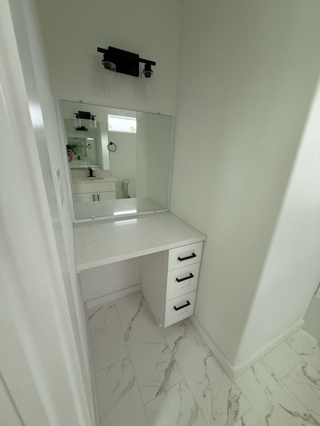 8019 Birmingham St, Houston, TX 77028 - bathroom with vanity, marble look tiles, baseboards, and toilet