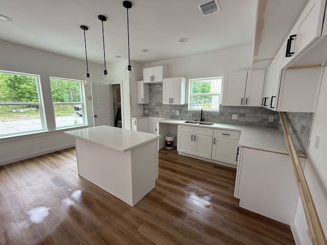 8019 Birmingham St, Houston, TX 77028 - kitchen featuring a sink, dark wood-style flooring, decorative backsplash, white cabinets, and recessed lighting