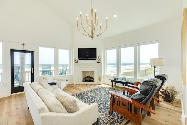 2176 Hwy 87, Gilchrist, TX 77617 - living room featuring healthy amount of natural light, light wood-style floors, a chandelier, and high vaulted ceiling