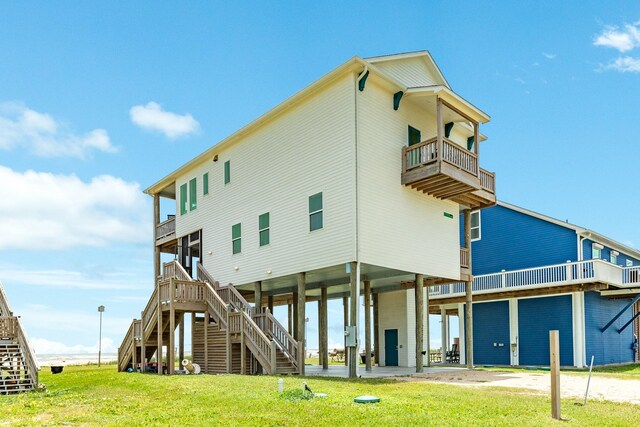 2176 Hwy 87, Gilchrist, TX 77617 - back of property featuring a balcony, a carport, stairway, a lawn, and driveway