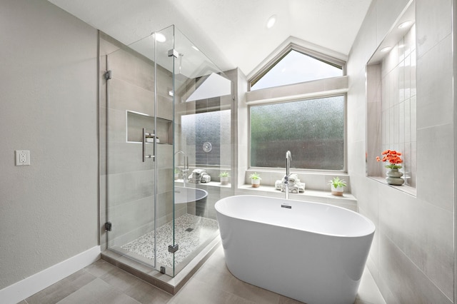 bathroom with a shower stall, a soaking tub, vaulted ceiling, baseboards, and recessed lighting