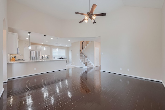 16747 Highland Country Dr, Cypress, TX 77433 - unfurnished living room featuring stairway, wood finished floors, ceiling fan, high vaulted ceiling, and recessed lighting