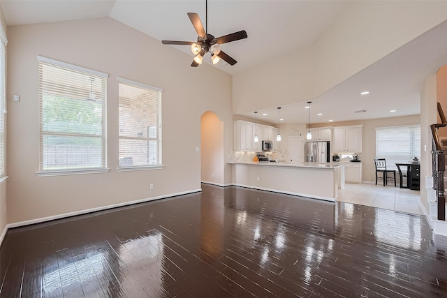 16747 Highland Country Dr, Cypress, TX 77433 - unfurnished living room featuring arched walkways, ceiling fan, light wood finished floors, and lofted ceiling