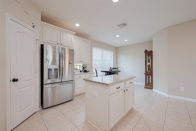 16747 Highland Country Dr, Cypress, TX 77433 - kitchen with stainless steel fridge, light tile patterned floors, a center island, white cabinetry, and recessed lighting