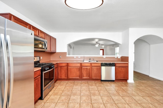 5818 Taylan Ln, Rosenberg, TX 77471 - kitchen featuring appliances with stainless steel finishes, a ceiling fan, arched walkways, and light countertops