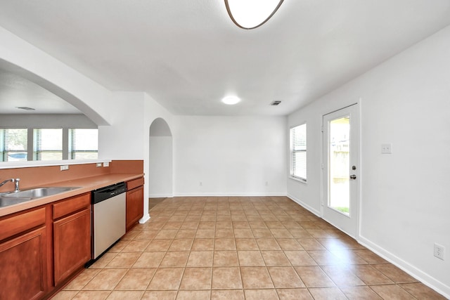 5818 Taylan Ln, Rosenberg, TX 77471 - kitchen featuring dishwasher, light tile patterned floors, a sink, light countertops, and brown cabinetry