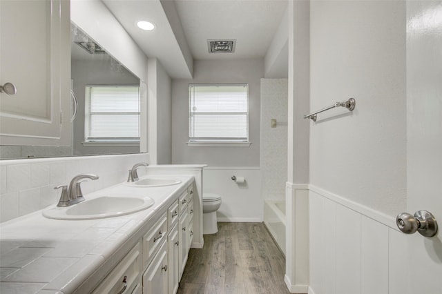 206 Verna St, Jasper, TX 75951 - full bath featuring toilet, wood finished floors, double vanity, and wainscoting