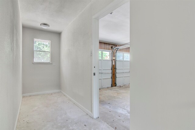 206 Verna St, Jasper, TX 75951 - hall featuring baseboards, plenty of natural light, and unfinished concrete floors