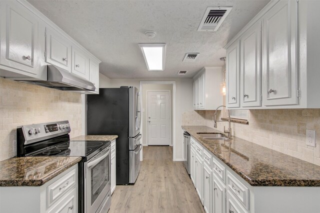 206 Verna St, Jasper, TX 75951 - kitchen featuring stainless steel appliances, a sink, under cabinet range hood, light wood-type flooring, and white cabinetry