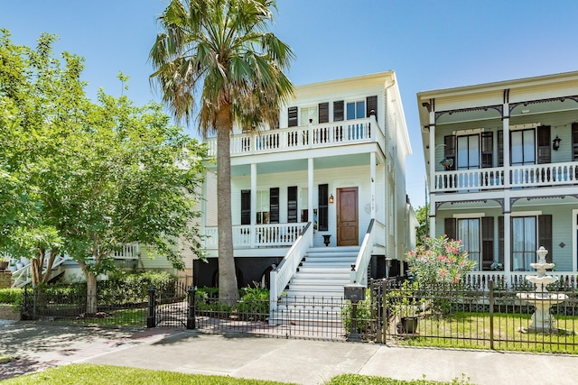 1717 Winnie St, Galveston, TX 77550 - view of front of property featuring a porch, a fenced front yard, a balcony, and stairway
