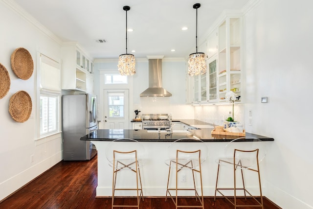 1717 Winnie St, Galveston, TX 77550 - kitchen with appliances with stainless steel finishes, wall chimney range hood, a chandelier, a peninsula, and glass insert cabinets