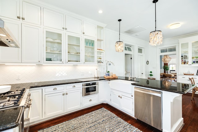 1717 Winnie St, Galveston, TX 77550 - kitchen with appliances with stainless steel finishes, a peninsula, a chandelier, white cabinetry, and tasteful backsplash