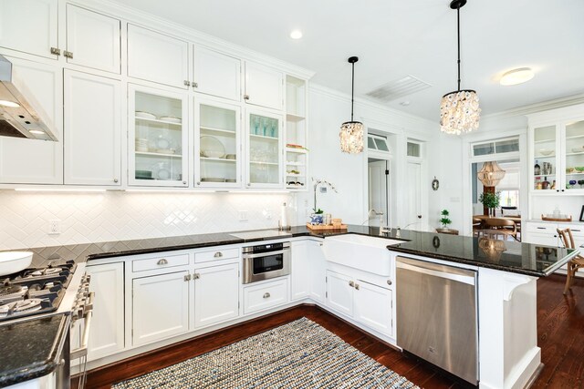 1717 Winnie St, Galveston, TX 77550 - kitchen featuring appliances with stainless steel finishes, a peninsula, a sink, a chandelier, and white cabinetry