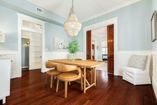 1717 Winnie St, Galveston, TX 77550 - dining space featuring dark wood-style flooring, a chandelier, crown molding, a wainscoted wall, and a decorative wall