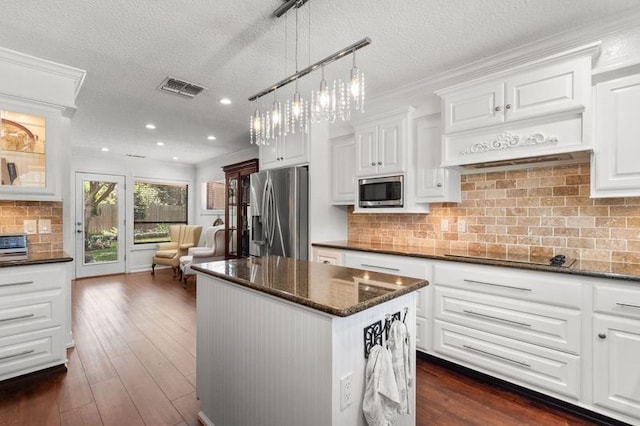 15106 Cranbourne Dr, Houston, TX 77062 - kitchen with appliances with stainless steel finishes, a textured ceiling, a center island, white cabinets, and recessed lighting