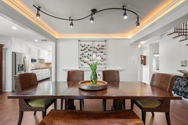 15106 Cranbourne Dr, Houston, TX 77062 - dining area featuring wood finished floors, crown molding, rail lighting, and a textured ceiling