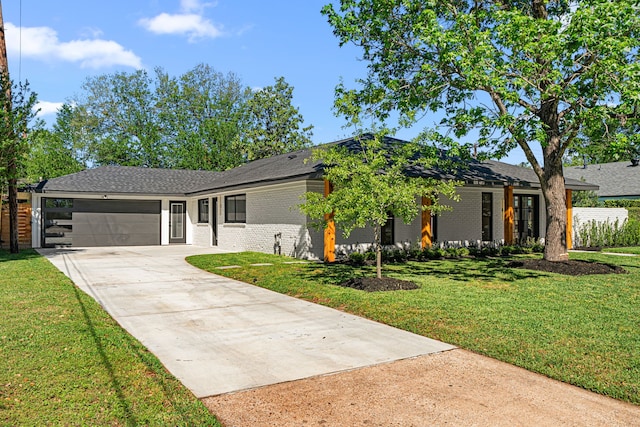 view of front of property with brick siding, driveway, an attached garage, a front yard, and roof with shingles