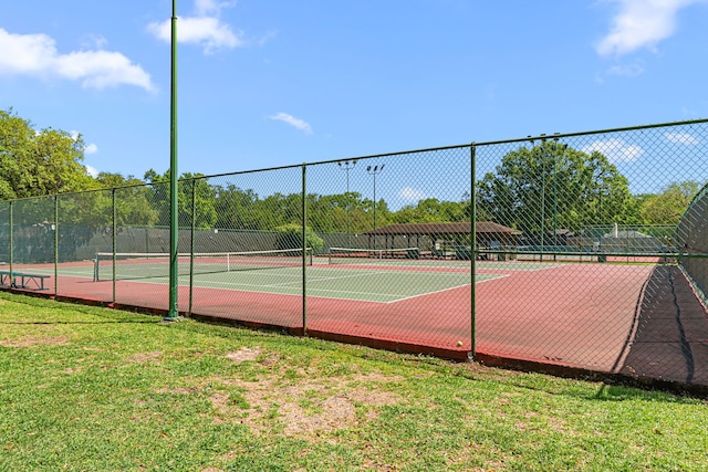view of tennis court featuring fence