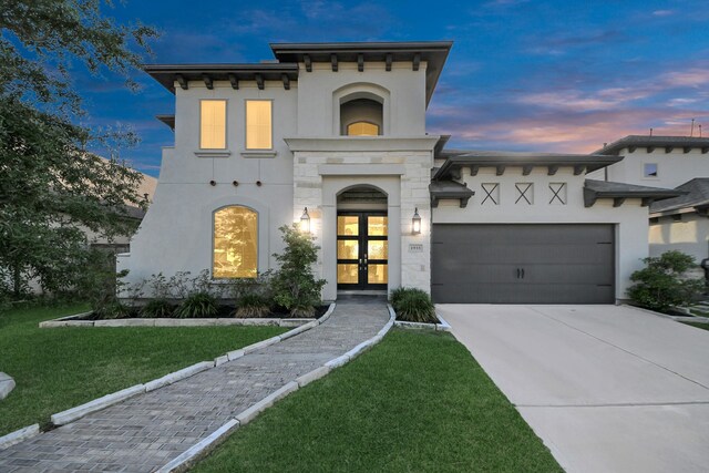 1935 Creekwood Cv, Missouri City, TX 77459 - view of front of home with stucco siding, french doors, an attached garage, and driveway