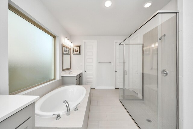 1935 Creekwood Cv, Missouri City, TX 77459 - bathroom featuring a shower stall, a garden tub, vanity, recessed lighting, and baseboards
