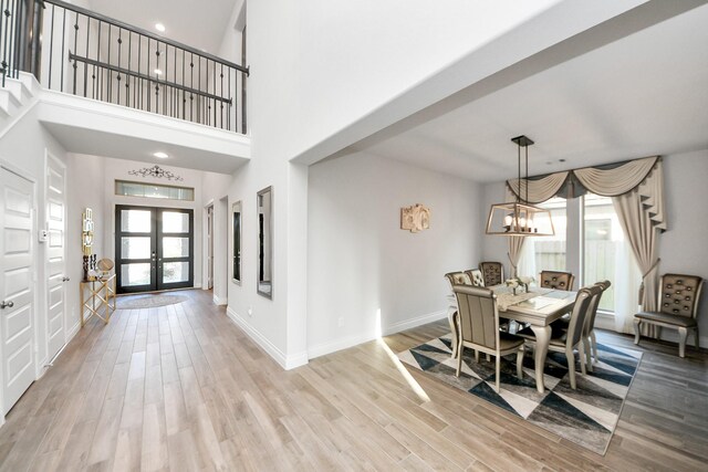 1935 Creekwood Cv, Missouri City, TX 77459 - dining area featuring a chandelier, light wood-style floors, french doors, baseboards, and a high ceiling