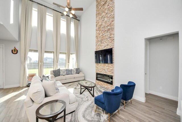 1935 Creekwood Cv, Missouri City, TX 77459 - living area featuring a towering ceiling, a ceiling fan, wood finished floors, and baseboards