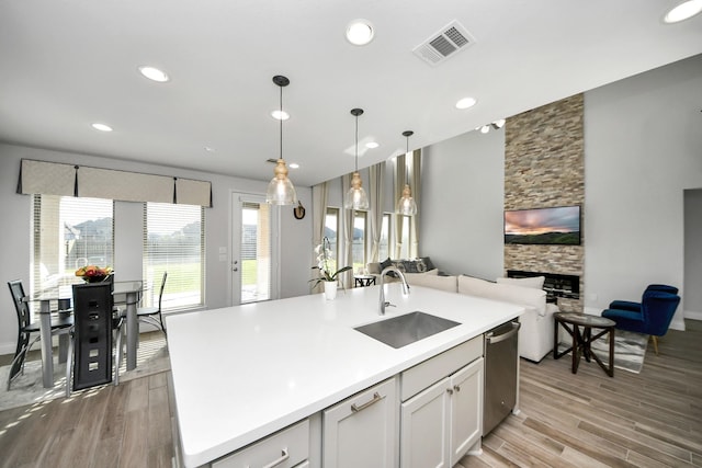 1935 Creekwood Cv, Missouri City, TX 77459 - kitchen with a sink, dishwasher, open floor plan, light wood-style floors, and recessed lighting