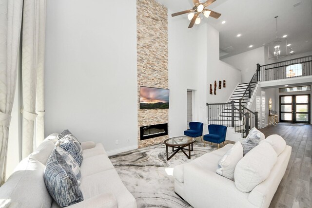 1935 Creekwood Cv, Missouri City, TX 77459 - living room featuring a towering ceiling, wood finished floors, stairway, a fireplace, and ceiling fan