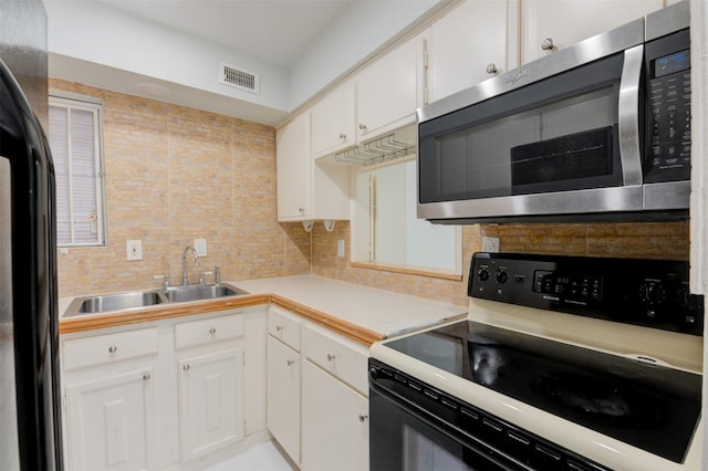7900 Westheimer Rd Unit 246, Houston, TX 77063 - kitchen with range with electric cooktop, stainless steel microwave, a sink, freestanding refrigerator, and tasteful backsplash