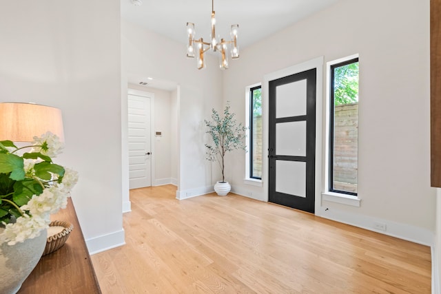 2621 Greenbriar Dr, Houston, TX 77098 - foyer featuring light wood-type flooring, a chandelier, and baseboards