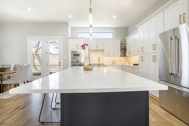 2216 Francis St, Houston, TX 77004 - kitchen featuring stainless steel appliances, decorative backsplash, light countertops, open shelves, and light wood-style flooring