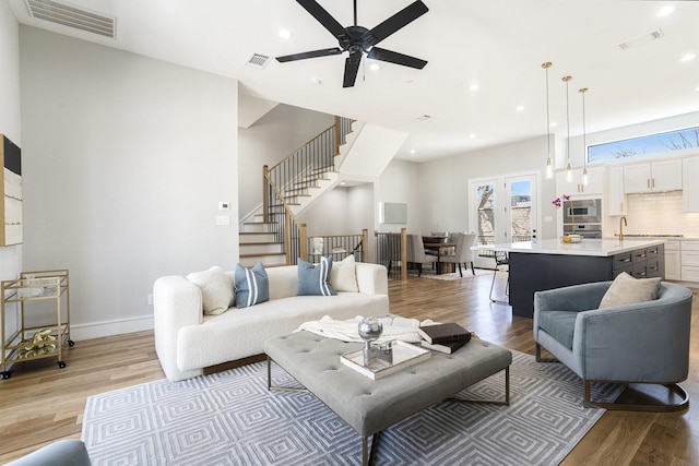2216 Francis St, Houston, TX 77004 - living room with light wood finished floors, recessed lighting, stairway, ceiling fan, and baseboards