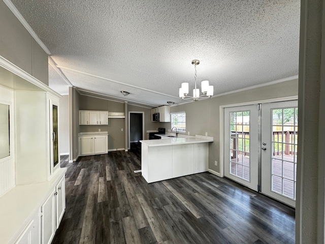 18549 Indigo Way, Porter, TX 77365 - kitchen with a peninsula, a textured ceiling, a chandelier, a sink, and dark wood finished floors