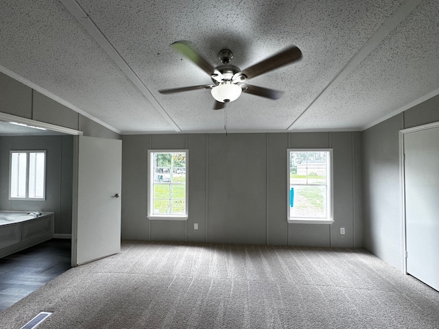 18549 Indigo Way, Porter, TX 77365 - unfurnished bedroom featuring carpet floors, a decorative wall, a textured ceiling, ceiling fan, and crown molding
