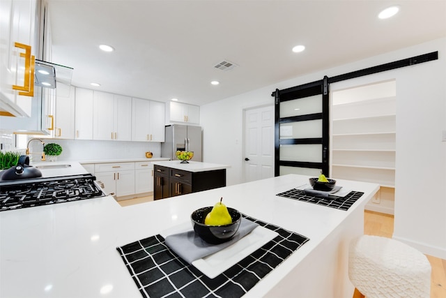 2514 Haverhill Dr, Houston, TX 77008 - kitchen with stainless steel fridge, light countertops, white cabinets, a kitchen island, and recessed lighting