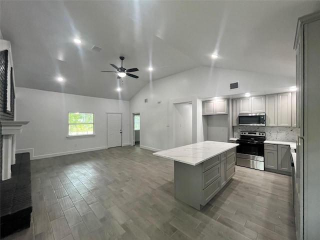 21268 White Oak Dr, Conroe, TX 77306 - kitchen featuring appliances with stainless steel finishes, gray cabinetry, ceiling fan, a kitchen island, and wood finished floors