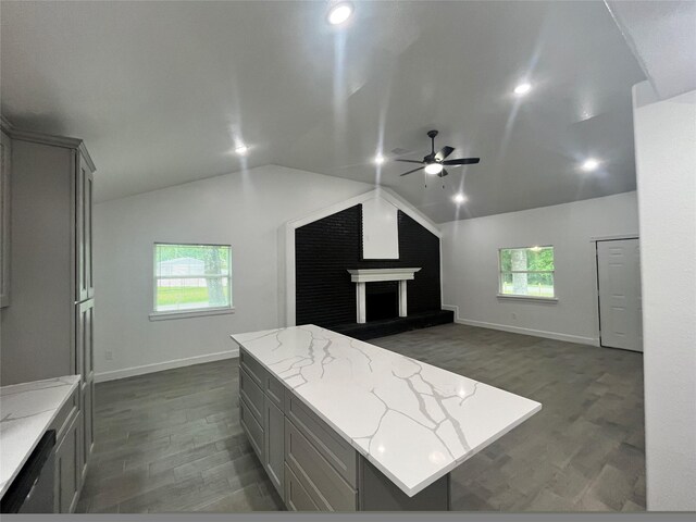 21268 White Oak Dr, Conroe, TX 77306 - bedroom with dark wood-style floors, vaulted ceiling, baseboards, a large fireplace, and a ceiling fan