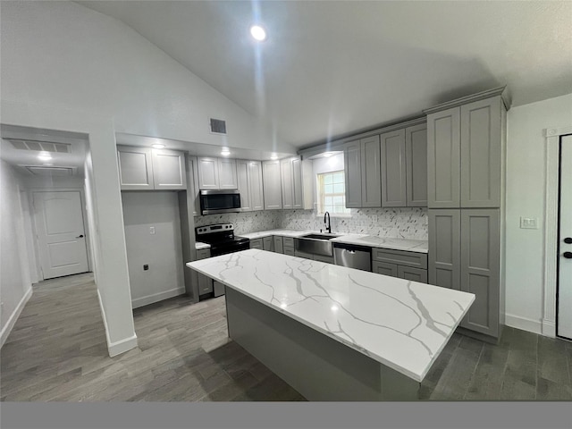 21268 White Oak Dr, Conroe, TX 77306 - kitchen with stainless steel appliances, a sink, backsplash, wood finished floors, and light stone countertops