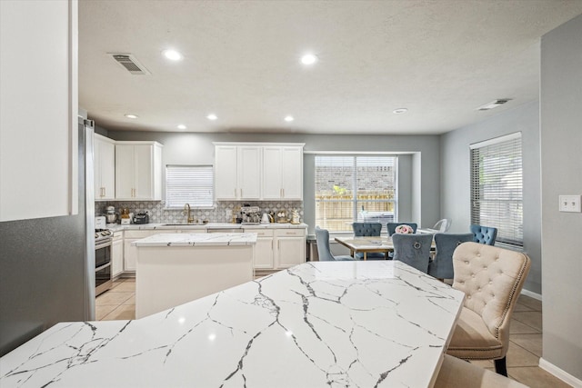 5206 Spring Oak Dr, Pasadena, TX 77505 - kitchen with light tile patterned flooring, double oven range, a center island, tasteful backsplash, and recessed lighting