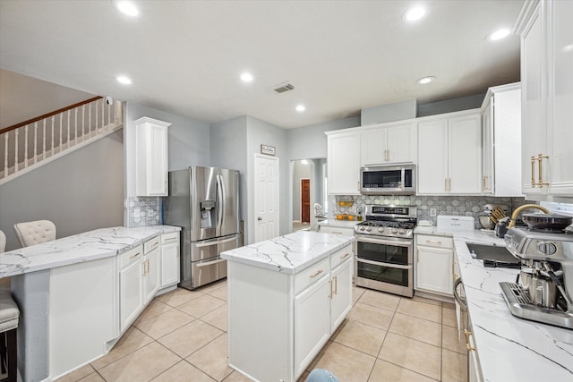 5206 Spring Oak Dr, Pasadena, TX 77505 - kitchen with appliances with stainless steel finishes, backsplash, light stone countertops, white cabinets, and recessed lighting