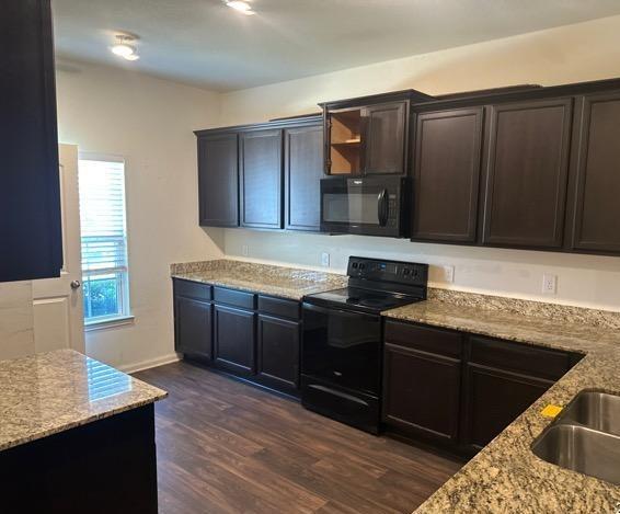 11822 Claudette St, San Antonio, TX 78252 - kitchen with black appliances, light stone countertops, and dark wood-style floors
