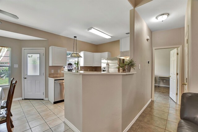 34606 Lake Side Dr, Brookshire, TX 77423 - kitchen with stainless steel appliances, light tile patterned floors, white cabinets, pendant lighting, and baseboards