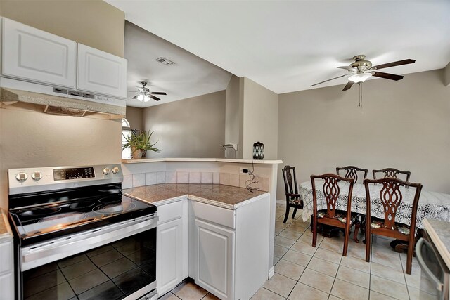 34606 Lake Side Dr, Brookshire, TX 77423 - kitchen with stainless steel range with electric stovetop, under cabinet range hood, ceiling fan, and a peninsula