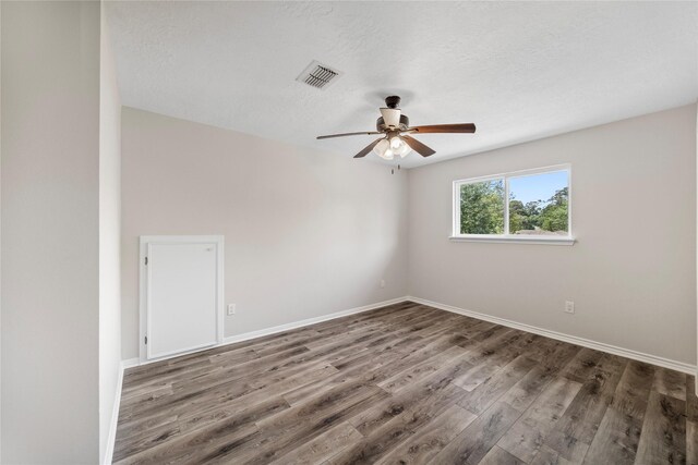 unfurnished room with a ceiling fan, wood finished floors, baseboards, and a textured ceiling