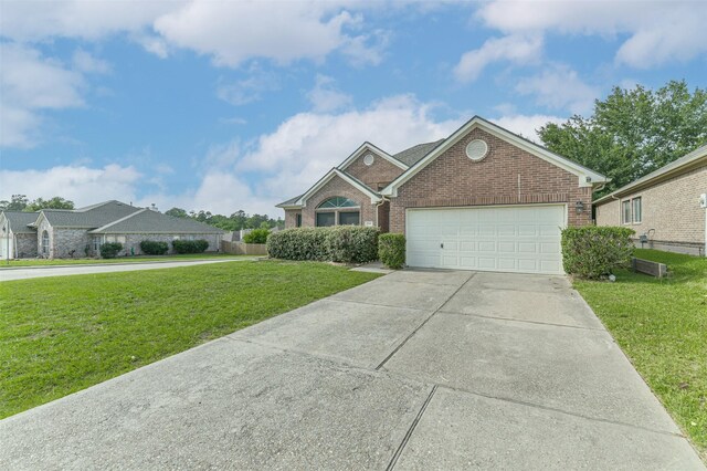 2212 Highland Crossing Dr, Conroe, TX 77304 - view of front facade featuring brick siding, a front yard, a garage, and driveway