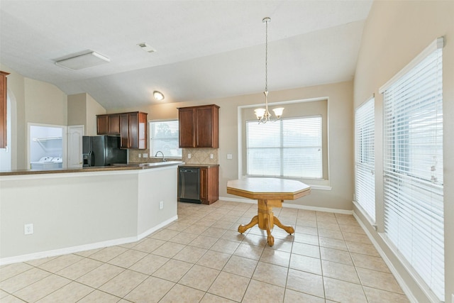 2212 Highland Crossing Dr, Conroe, TX 77304 - kitchen with black appliances, vaulted ceiling, decorative backsplash, a chandelier, and light tile patterned flooring